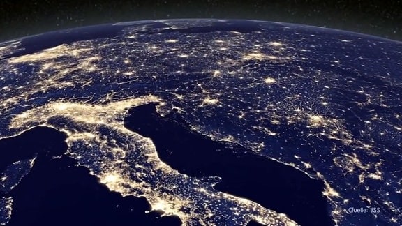 Blick auf die nachts hell erleuchtete Erde von der Raumstation aus.