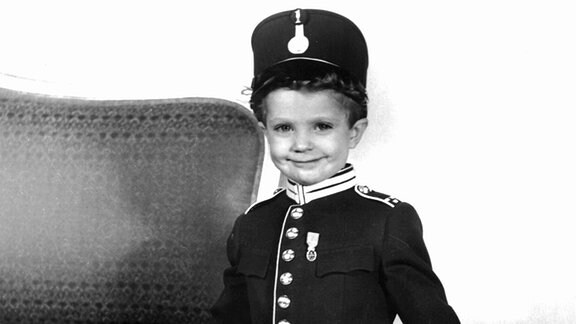 Der damals dreieinhalb Jahre alte schwedische Prinz und spätere König, Carl Gustaf, posiert mit seiner ersten Uniform für den Fotografen.