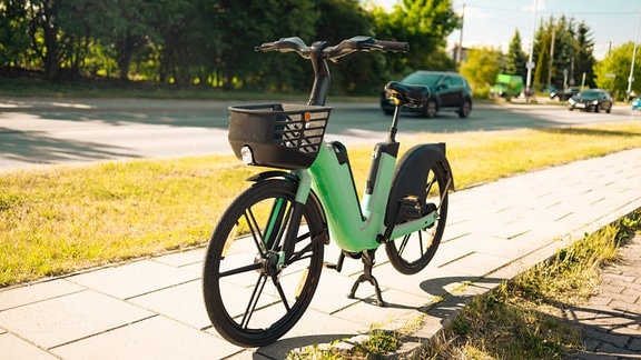 Ein grünes E-Bike steht auf einem Bürgersteig in Paris.