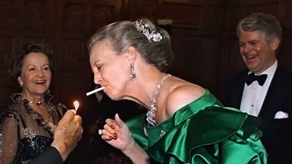 Mit einer Zigarette im Mund lässt sich Königin Margrethe II. von Dänemark bei einem Galadinner in New York Feuer geben.