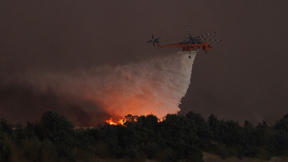 Ein Hubschrauber wirft Wasser über einem Waldbrand im Dorf Avantas in der Nähe der Stadt Alexandroupolis in der nordöstlichen Region Evros ab. 