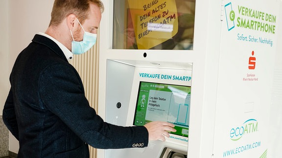 Ein Mitarbeiter demonstriert in einer Filiale der Sparkasse die Funktionsweise des sogenannten «ko-Geldautomaten».