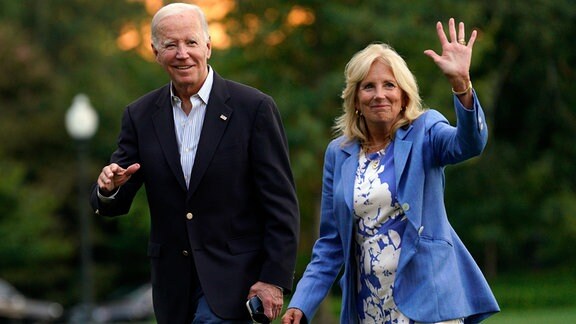 Jill und Joe Biden gehen im Grünen und winken