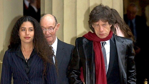 Rolling Stone Sir Mick Jagger (r), Vater Joe und seine Tochter Karis (l), nachdem er während einer Zeremonie im Buckingham Palace vom Prinzen von Wales am Freitag, dem 12. Dezember 2003, für seine Verdienste um die Popmusik zum Ritter geschlagen wurde.