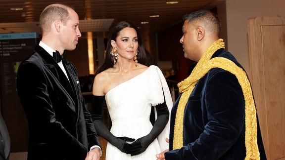 Der britische Prinz William, links, und Kate, die Prinzessin von Wales, sprechen mit Krishnendu Majumdar, dem Vorsitzenden der BAFTA.