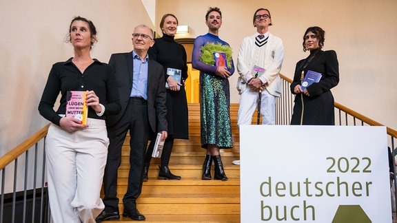 Fatma Aydemir', Kristine Bilkau, Daniela Dröscher, Jan Faktor', Kim de l’Horizon und Eckhart Nickel stehen mit ihren jeweiligen Büchern auf einer Treppe.