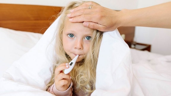 Krankes Mädchen hält Fieberthermometer im Mund