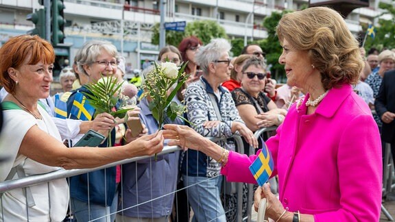 Königin Silvia von Schweden spricht nach der feierlichen Eröffnung des Wohnquartiers für an Demenz erkrankte Menschen mit Anwohnern.