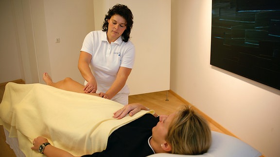 Physiotherapeutin führt Lymphdrainage an Patientin durch.