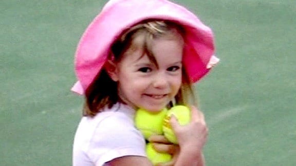 Madeleine McCann (Maddie) hält Tennisbälle in der Hand.