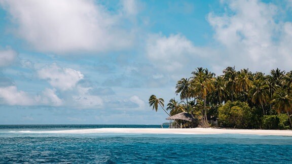 Wolken über tropischem Strand einer Insel der Malediven