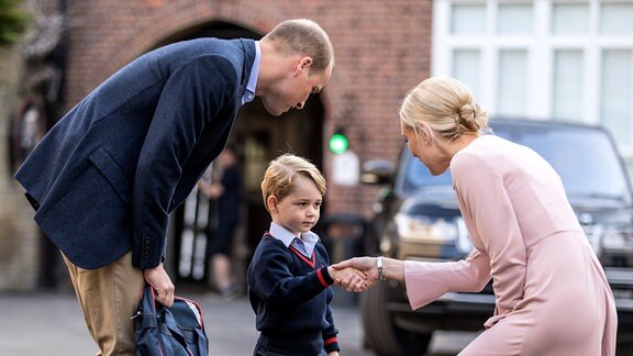 Prinz George (M) und sein Vater, der britische Prinz William, werden am 07.09.2017 in London (Großbritannien) von der Schulleiterin, Helen Haslem an der Thomas's Battersea Schule begrüßt.