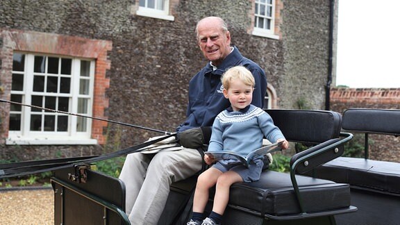 Prinz Philip sitzt mit Prinz George auf einem Kutschbock