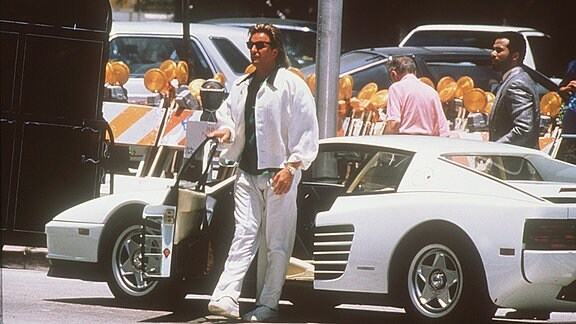 Hauptdarsteller Don Johnson in einer Szene der amerikanischen TV-Serie Miami Vice vor seinem Ferrari Testarossa, aufgenommen 1987