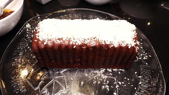 Ein brauner Kuchen mit weißem Topping.