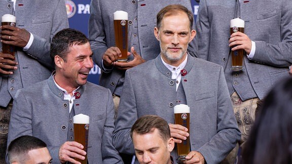 Co-Trainer Zsolt Loew (l) und Trainer Thomas Tuchel prosten während des Paulaner & FCB-Fototermins mit einem Bier.