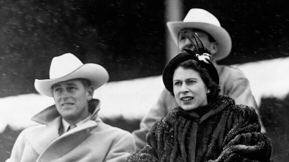 Königin Elizabeth II. (r) und Prinz Philip schauen sich die extra für sie aufgeführte "Stampede"- Rodeoshow an während ihrer Kanadareise 1951. 