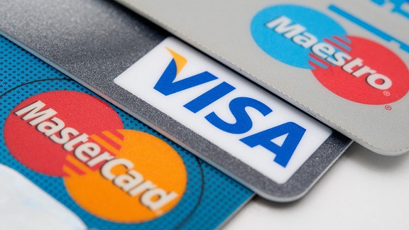 Kreditkarten der Kreditkartengesellschaften Visa und MasterCard sowie eine EC-Karte des Debitkarten-Dienstes Maestro liegen nebeneinander.