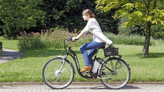 Eine Frau fährt mit einem Elektrofahrrad e-bike citystar mit austauschbarem Lithium-Ionen-Akku 