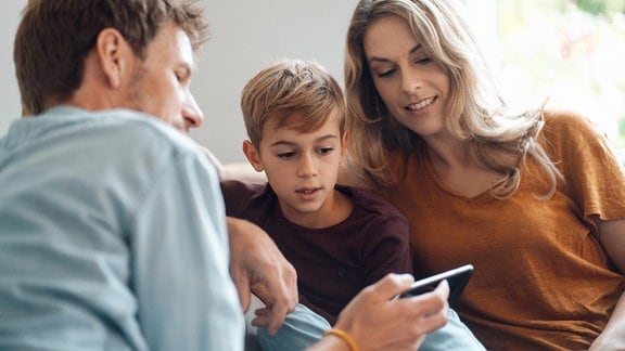 Eine familie schaut auf ein Smartphone