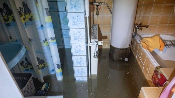 Ein Badezimmer ist mit schmutzigem Wasser überflutet.