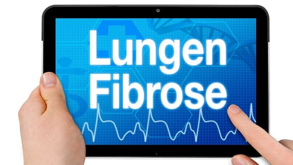 Schriftzug 'Lungenfibrose' und EKG-Kurve auf einem Tablet