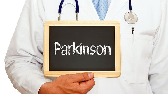 Illustration: Ein Arzt hält eine Tafel mit der Aufschrift «Parkinson».