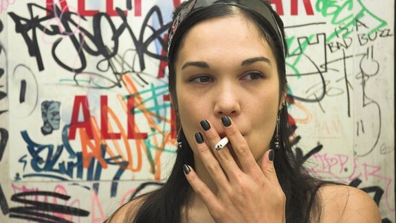 Junge Frau raucht eine Zigarette 