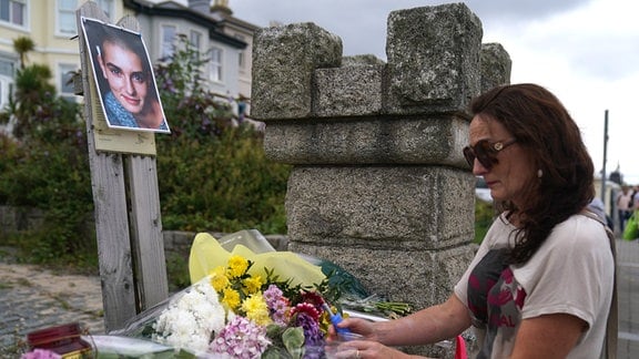 Olivia Galvin aus Kerry zündet nach dem Tod von der Sängerin Sinead O'Connor eine Kerze vor ihrem ehemaligen Haus in Bray,