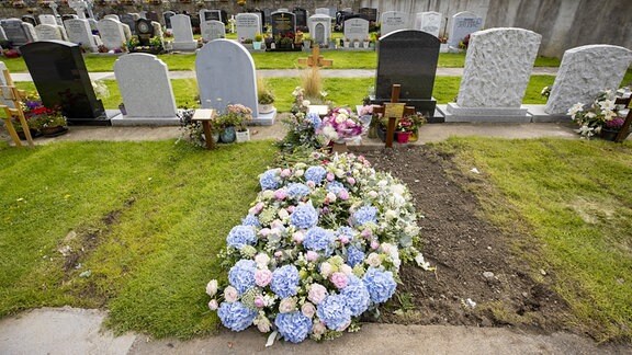 Blumen liegen am Grab der irischen Sängerin Sinead O'Connor auf dem Deansgrange-Friedhof.