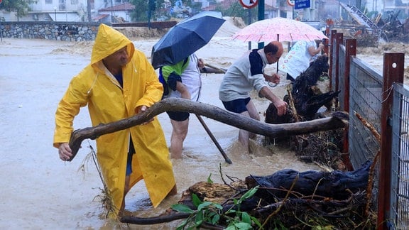 Anwohner entfernen Trümmer aus einem überfluteten Gebiet.
