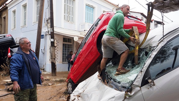 Ein Bulldozer versucht nach einem Rekordregen ein beschädigtes Auto aus dem Schlamm zu ziehen. 