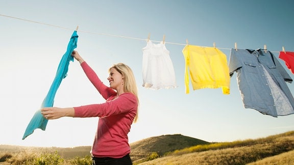 Eine Frau hängt Wäsche auf.
