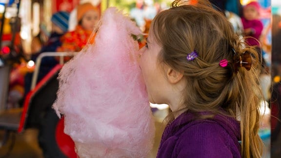 Ein Mädchen isst Zuckerwatte