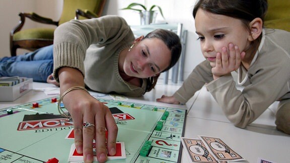 Zwei Mädchen spielen Monopoly.