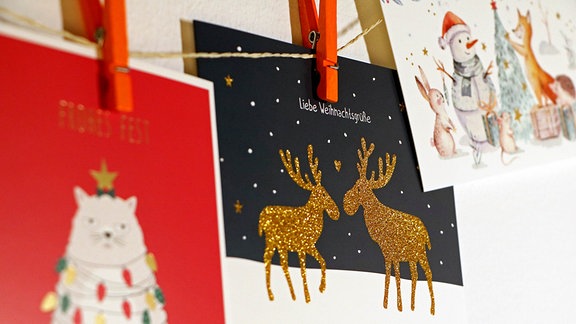 Weihnachtskarten hängen mit Wäscheklammern an einer Schnur