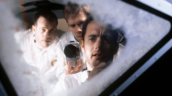 Szene aus dem Film ''Apollo 13''. Die Astronauten schauen zum Fenster hinaus auf den Mond.