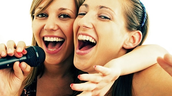 zwei Sängerinnen mit Mikrofon in der Hand