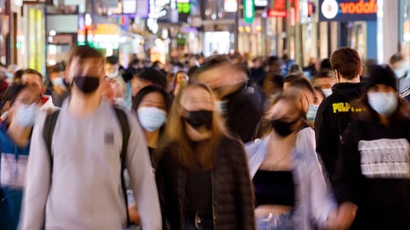 Menschen in der Hohe Straße, wo aufgrund des engen Abstandes zwischen den Passanten Maskenpflicht gilt.
