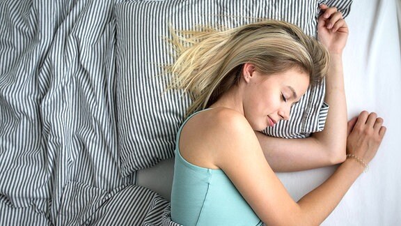 Eine junge Frau schläft in einem Bett