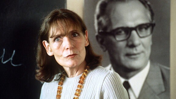 Die Schuldirektorin (Margit Carstensen) und das Honecker-Porträt an der Wand