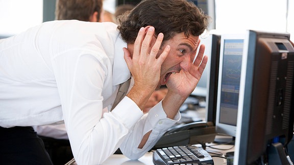 Symbolbild - Stress auf Arbeit - Ein Büroarbeiter schreit seinen Bildschirm an
