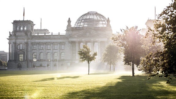 Der Reichstag zeichnet sich ab vor der aufgehenden Sonne in Berlin.