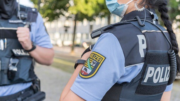 Ein Mann und eine Frau in Uniformen der Polizei Sachsen-Anhalt unterhalten sich