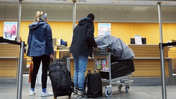 Reisende warten am Gepäckschalter des Flughafen Erfurt-Weimar.