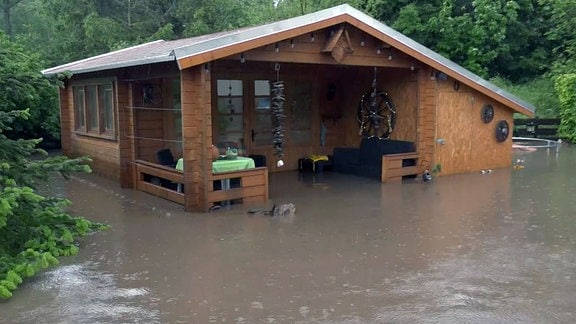 Ein Gartenhaus steht völlig unter Wasser.
