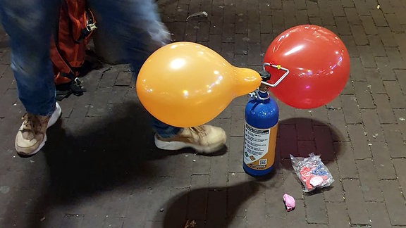 Ein Straßenhändler verkauft mit Lachgas gefüllte Luftballons am Rembrandtplein, einem Vergnügungsviertel. Die Ballons werden an Ort und Stelle aufgeblasen und die Kunden inhalieren auch auf der Straße.