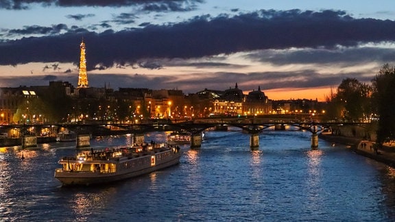 Nachtansicht von Paris mit der Seine, der Brücke Pont des Arts und dem Eiffelturm im Hintergrund