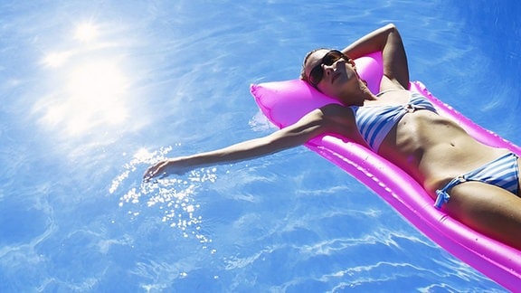 Frau auf einer Luftmatratze in einem Swimming Pool