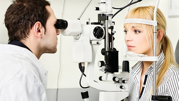 Eine Frau wird von einem Augenarzt untersucht